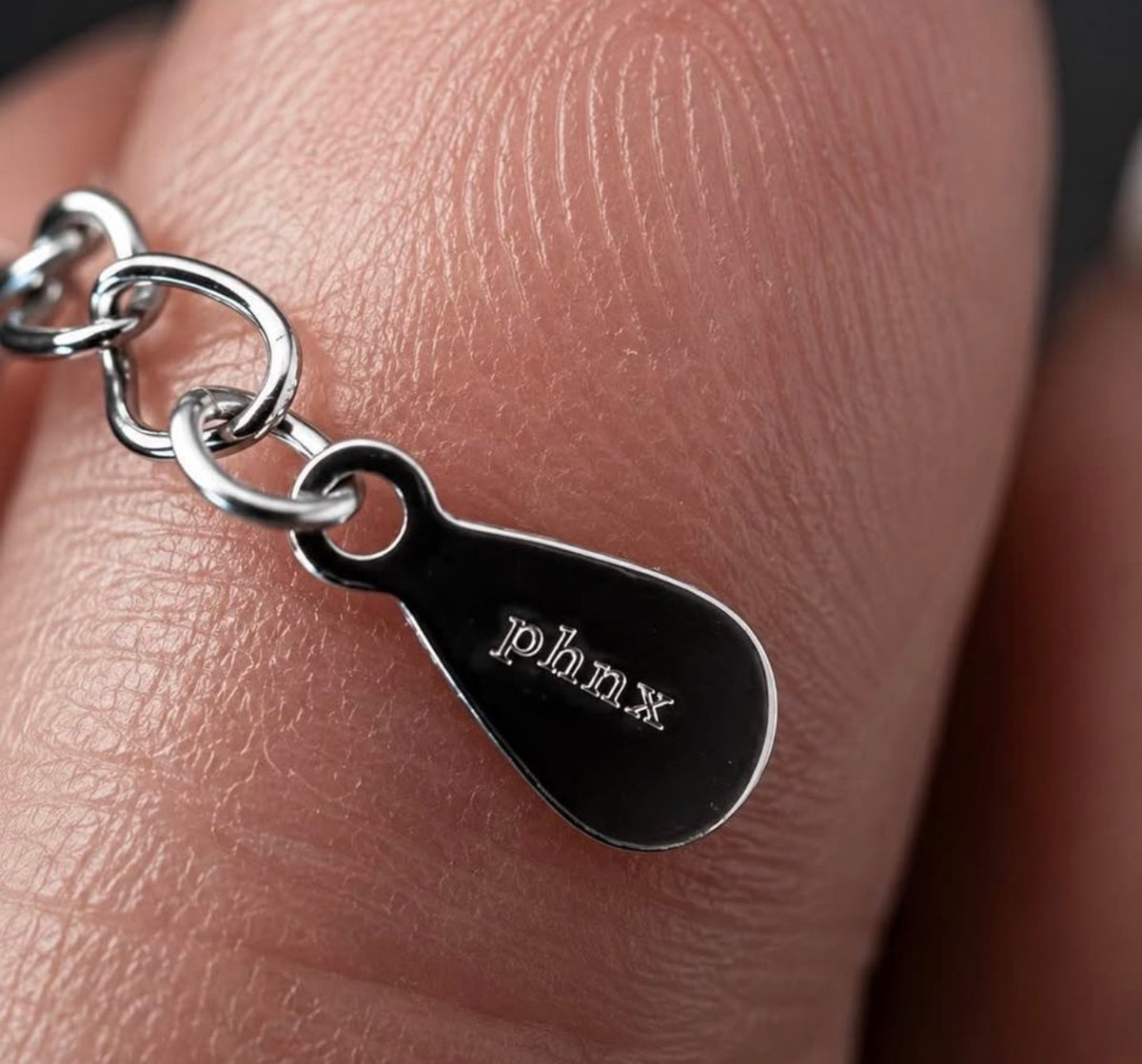 PHNX brand hallmark tag on platinum necklace