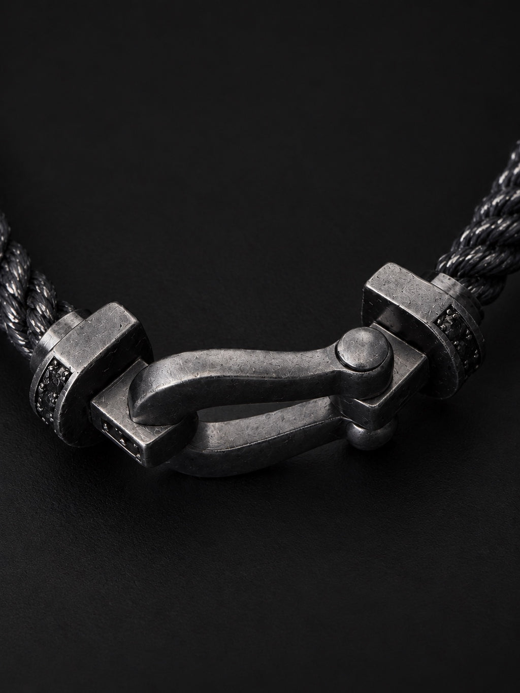 Close-up of PHNX black cord horseshoe bracelet clasp