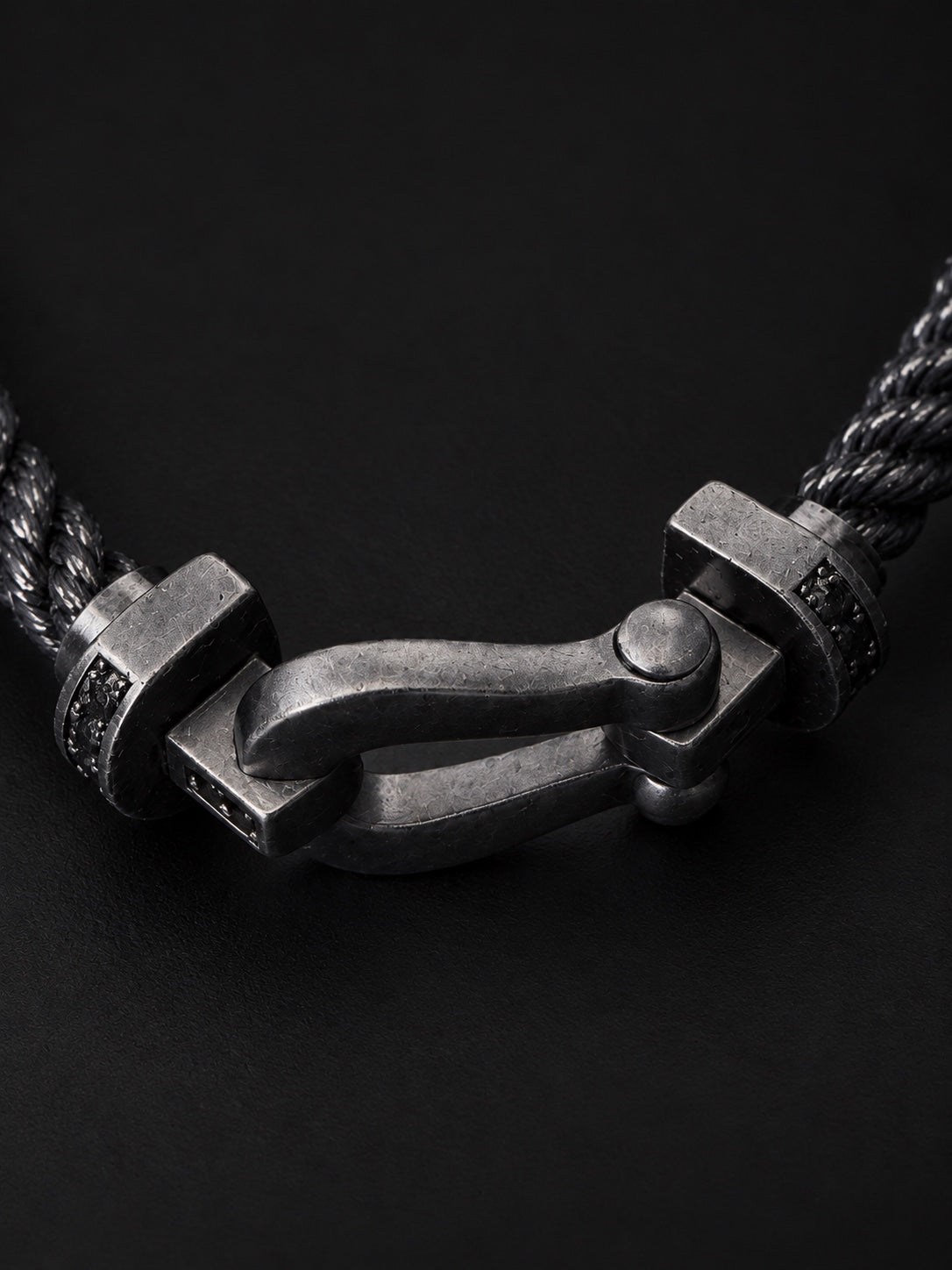 Close-up of PHNX black cord horseshoe bracelet clasp